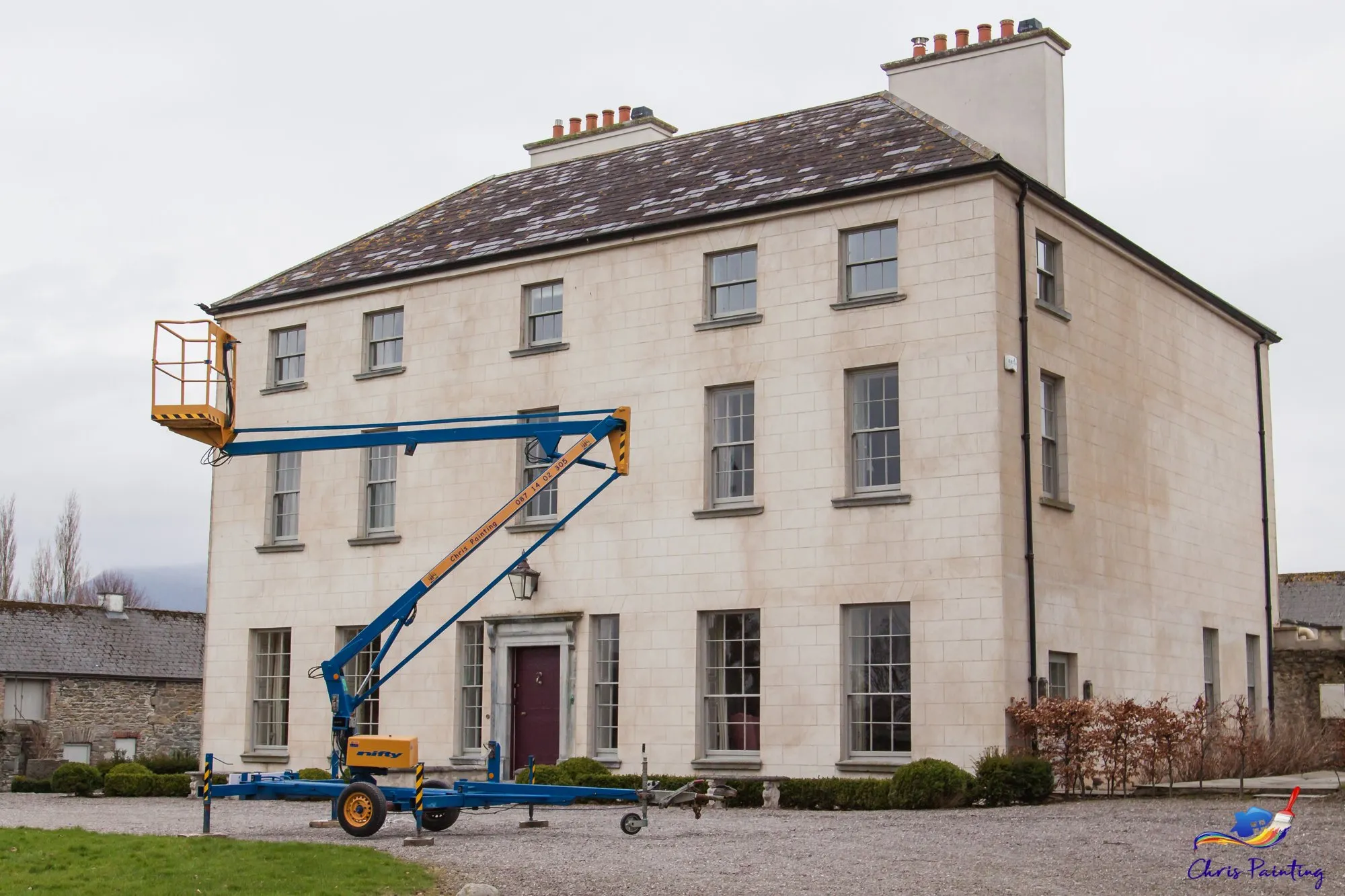 A Georgian house being painted from a raised lift