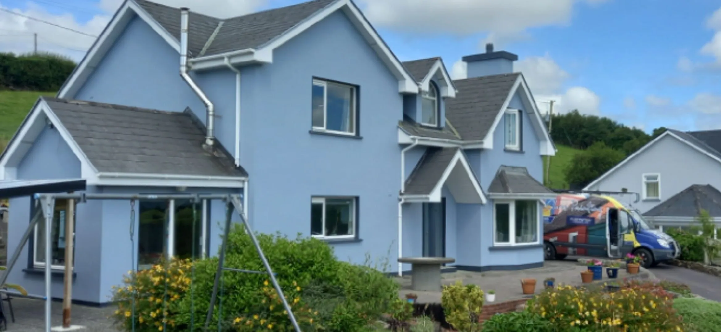 The same house painted soft blue with white trim